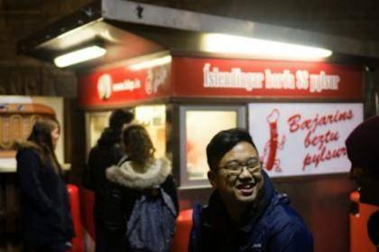People queuing at a hot dog stand in downtown Reykjavík at night