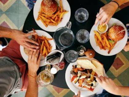 Friends sharing burgers and fries at a restaurant table